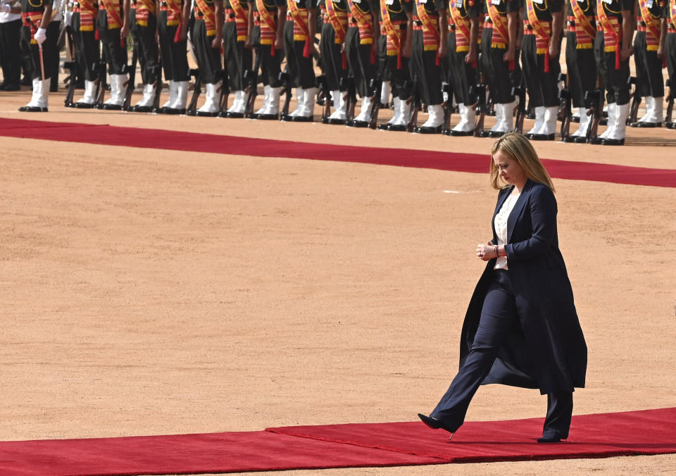 Italian Premier Giorgia Meloni returns after inspecting a guard of honor during a ceremonial reception at the Indian Presidential Palace in New Delhi, India, Thursday, March 2, 2023. (AP Photo)