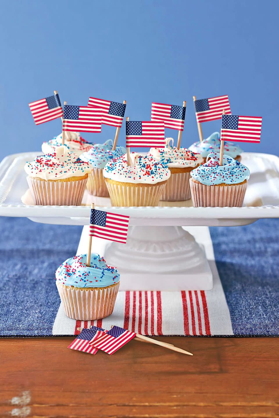 cupcakes with mini flags in them on a platter