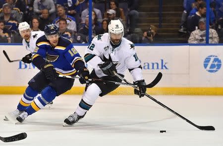 May 15, 2016; St. Louis, MO, USA; St. Louis Blues center Jori Lehtera (12) reaches for the puck on San Jose Sharks center Patrick Marleau (12) during the second period in game one of the Western Conference Final of the 2016 Stanley Cup Playoffs at Scottrade Center. Mandatory Credit: Jasen Vinlove-USA TODAY Sports