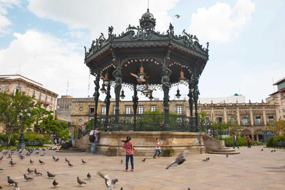 Children and pigeons in the Plaza de Armas, in Guadalajara, Mexico