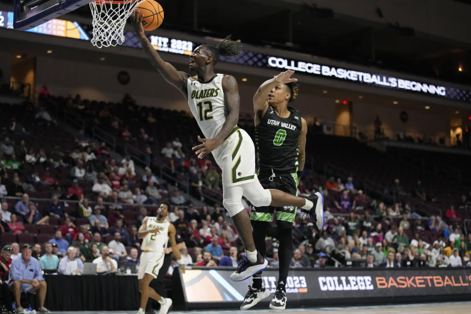 UAB's Tony Toney (12) shoots around Utah Valley's Justin Harmon (0) during the first half of an NCAA college basketball game in the semifinals of the NIT, Tuesday, March 28, 2023, in Las Vegas. (AP Photo/John Locher)