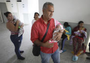 El expolicía venezolano Eduardo Bravo acuna a su hija Aranza Gabriela Bravo mientras espera en el hospital Erazmo Meoz a recibir su certificado de nacimiento, en Cúcuta, Colombia, el jueves 2 de mayo de 2019. (AP Foto/Fernando Vergara)