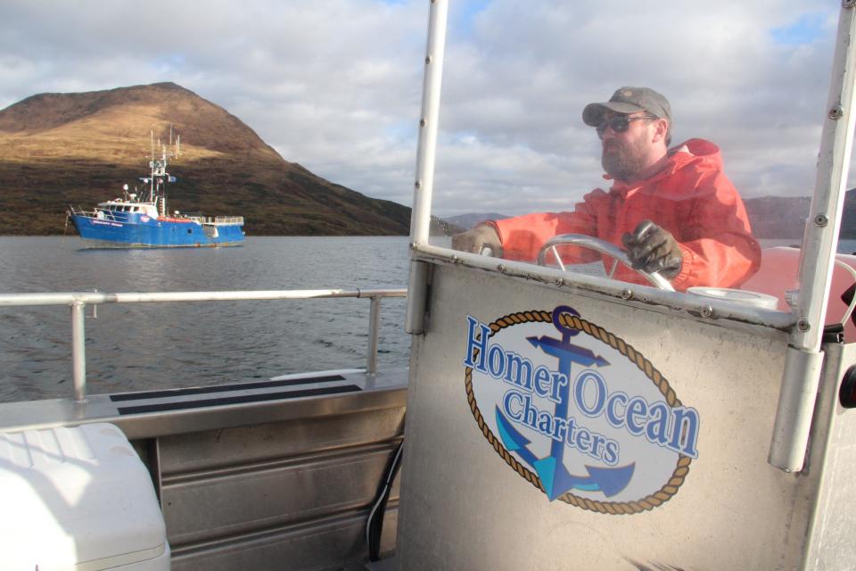 Zach Porter of Homer Ocean Charters drives a tender boat near Valiant Maid, an 82-foot boat used as the main vessel for a fishing, hunting and crabbing trip along the coast of Kodiak Island, Alaska.