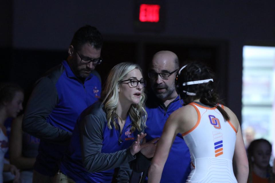 Olentangy Orange coaches Jack Garren, Vanessa Oswalt and Brian Nicola give instruction to Josie Nickoloff during a stoppage at the OHSWCA girls wrestling state duals Jan. 23 at Marysville.