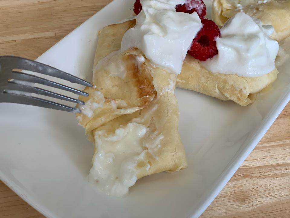 fork cutting open trader joe's blintzes on white plate