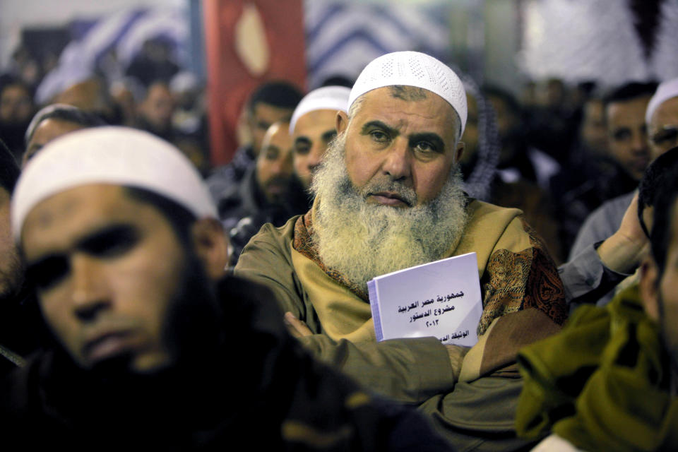 FILE - In this Thursday, Jan. 9, 2014 file photo, an Egyptian Salafi holds a copy of the new constitution as he attends a conference to hear a lecture entitled "Know Your Constitution," ahead of a two-day vote on a draft amendment in El-Saf village, 50 kilometers (31 miles) south of Cairo, Egypt. With a presidential run by Egypt’s powerful military chief seeming more likely by the day, this week’s two-day constitution referendum, to be held amid a massive security force deployment, is widely seen as a vote of confidence in the regime he installed last summer. Arabic reads, "the constitution of the Arab Republic of Egypt." (AP Photo/Amr Nabil, File)