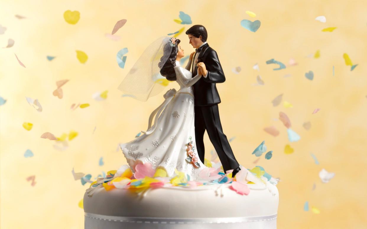 Bride and groom on a cake - Peter Dazeley/The Image Bank RF