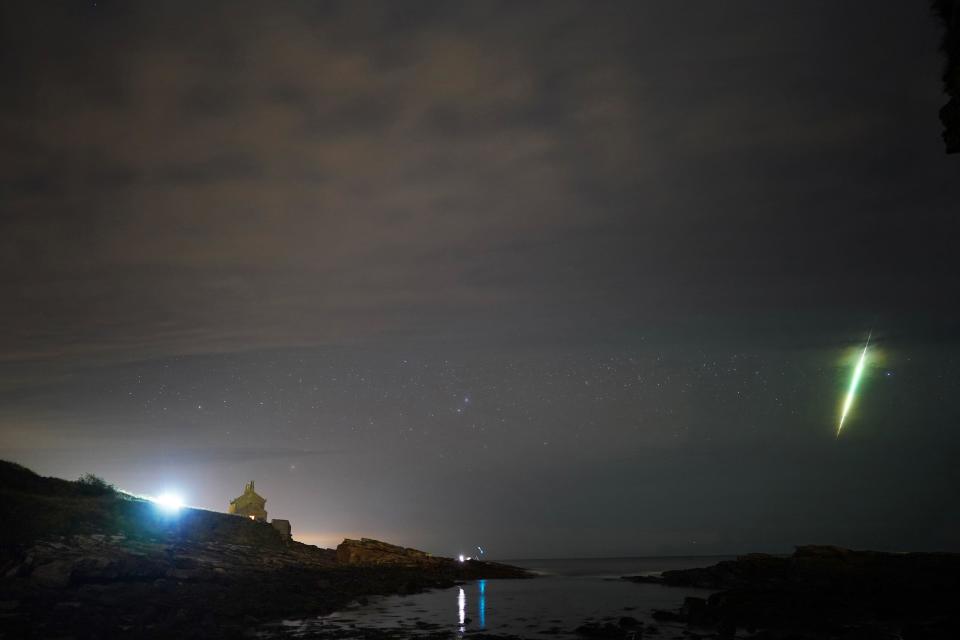 A fisherman watches a meteor during the Draconid meteor shower over Howick rocks in Northumberland. Picture date: Sunday October 10, 2021.