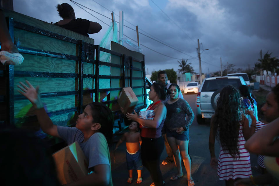 Hurricane survivors receive food and water being distributed by volunteers and municipal police as they deal with the aftermath of Hurricane Maria on Thursday in Toa Baja, Puerto Rico. (Photo: Joe Raedle via Getty Images)