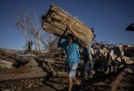 Workers recover tobacco from a drying barn that was destroyed one week ago by Hurricane Ian in La Coloma, Pinar del Rio province, Cuba, Wednesday, Oct. 5, 2022. (AP Photo/Ramon Espinosa)