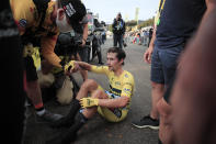 Slovenia's Primoz Roglic gets help from a team member after losing the overall leader's yellow jersey after stage 20 of the Tour de France cycling race, an individual time trial over 36.2 kilometers (22.5 miles), from Lure to La Planche des Belles Filles, France, Saturday, Sept. 19, 2020. (Christophe Petit-Tesson/Pool via AP)