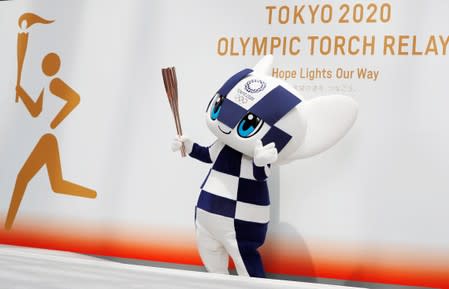 Tokyo 2020 Olympic Games mascot Miraitowa holds the torch of the Tokyo 2020 Olympic Games during a Torch Relay event to mark the 300-day milestone to the starting date of the torch relay, in Tokyo