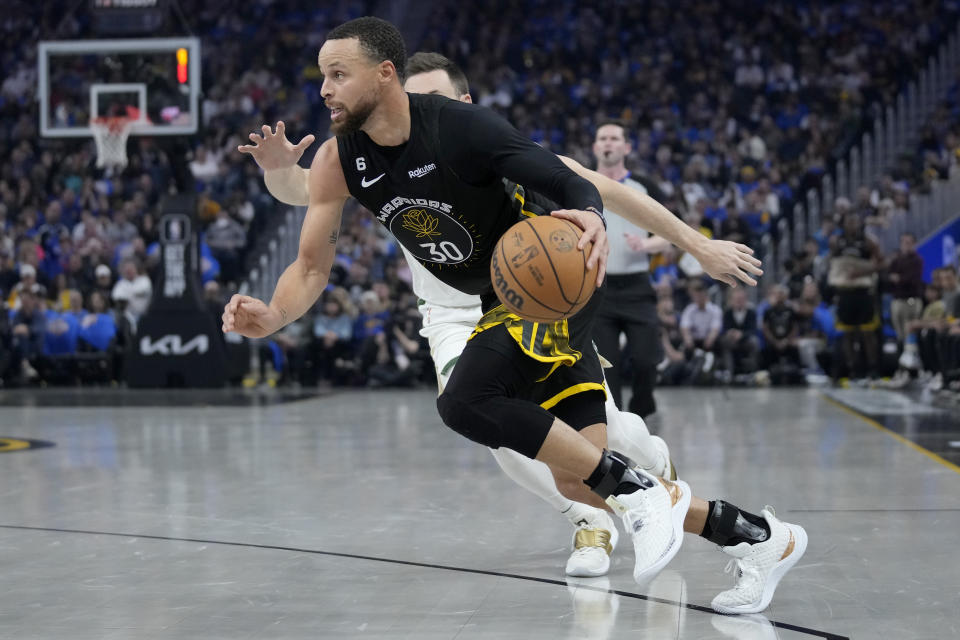 Golden State Warriors guard Stephen Curry (30) drives to the basket against Milwaukee Bucks guard Pat Connaughton during the first half of an NBA basketball game in San Francisco, Saturday, March 11, 2023. (AP Photo/Jeff Chiu)
