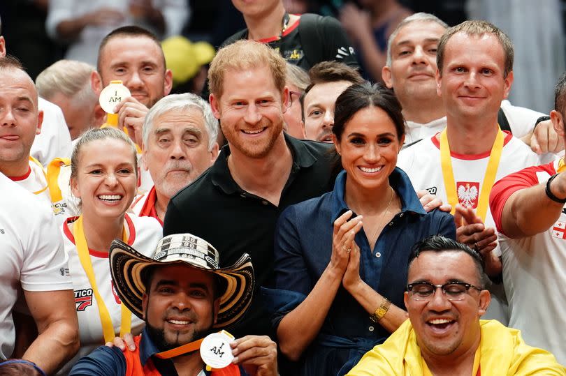 The Duke and Duchess of Sussex surrounded by medal winners during an Invictus Games