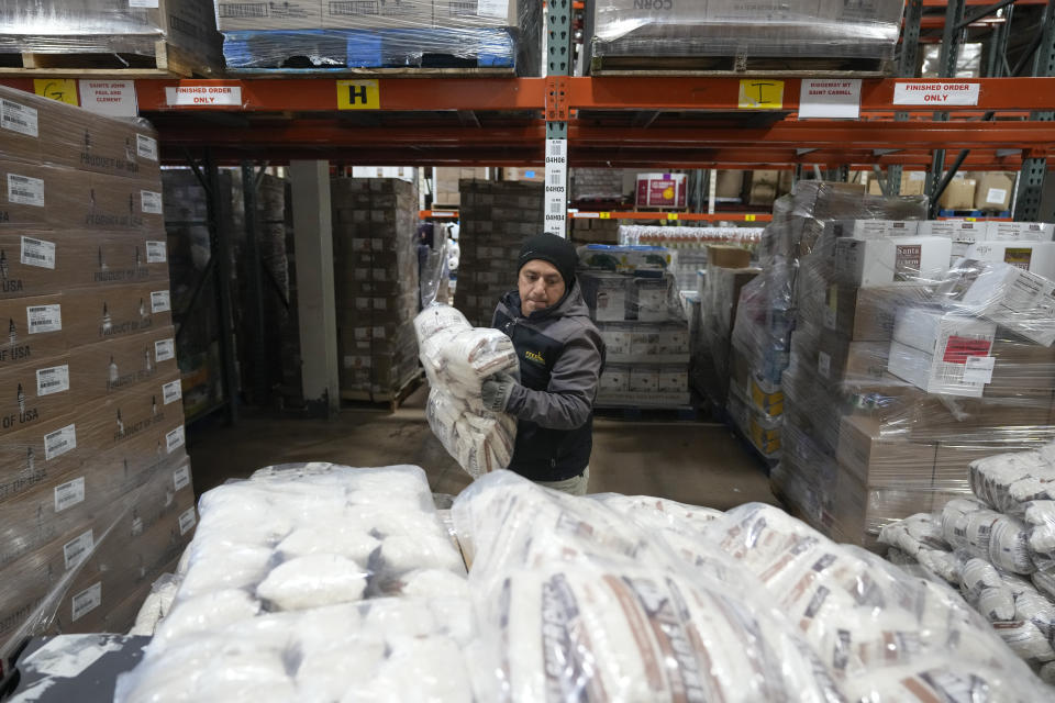 El conductor Carlos Quezada carga sacos de arroz para distribuirlos en Feeding Westchester, en Elmsford, Nueva York, el 15 de noviembre de 2023. Cada vez más estados trabajan para evitar la llegada de alimentos a los vertederos ante el temor a que ocupen demasiado espacio y causen problemas ambientales. (AP Foto/Seth Wenig)