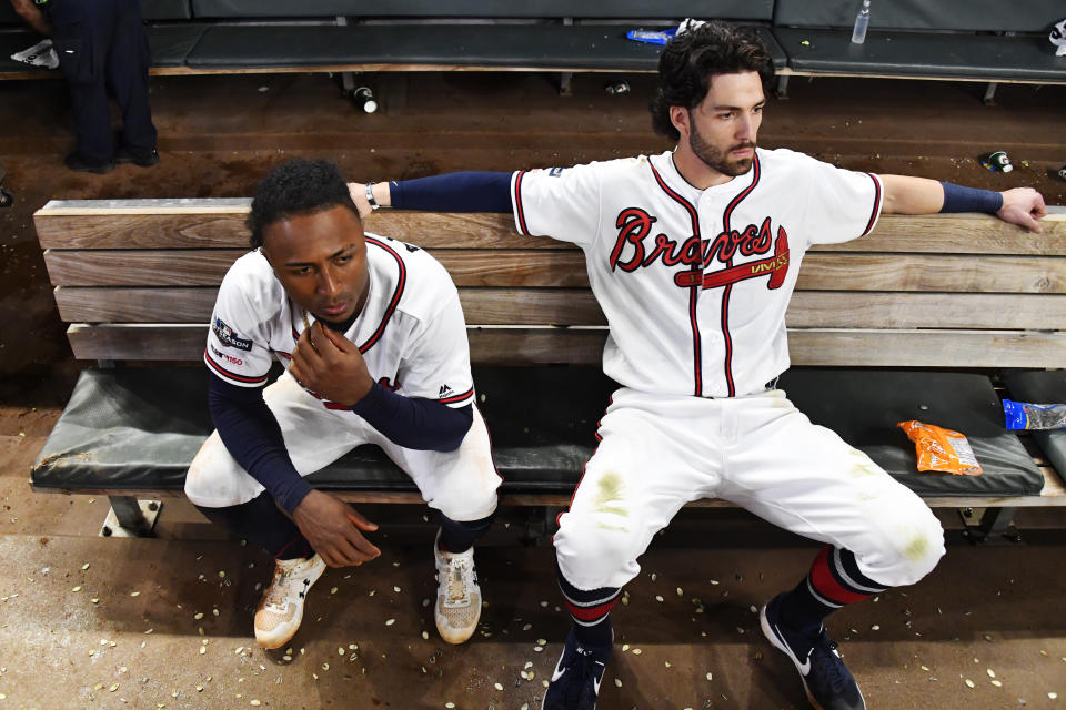 Atlanta Braves' Dansby Swanson, right, and Ozzie Albies sit in the dugout after the Braves lost 13-1 to the St. Louis Cardinals in Game 5 of their National League Division Series baseball game Wednesday, Oct. 9, 2019, in Atlanta. (AP Photo/John Amis)