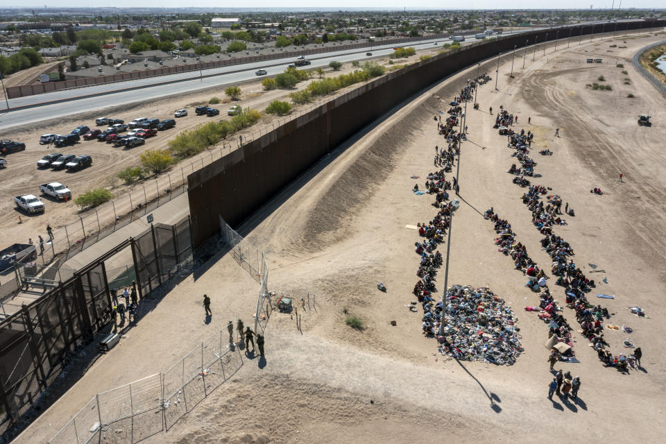 ARCHIVO - Migrantes forman filas afuera de la valla fronteriza para ser trasladados a una instalación de la Patrulla Fronteriza de Estados Unidos en El Paso, Texas, el 10 de mayo de 2023. (AP Foto/Andres Leighton, Archivo)