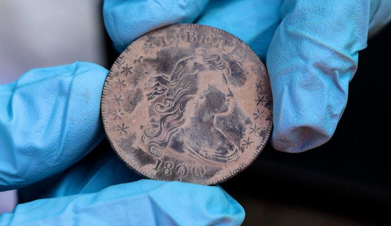 A Liberty dollar coin from 1800 was among artifacts found in the dried silt of a time capsule discovered beneath the Thaddeus Kosciuszko monument at West Point. An Aug. 28, 2023, ceremony seemed to end in disappointment, but further digging revealed the coins.