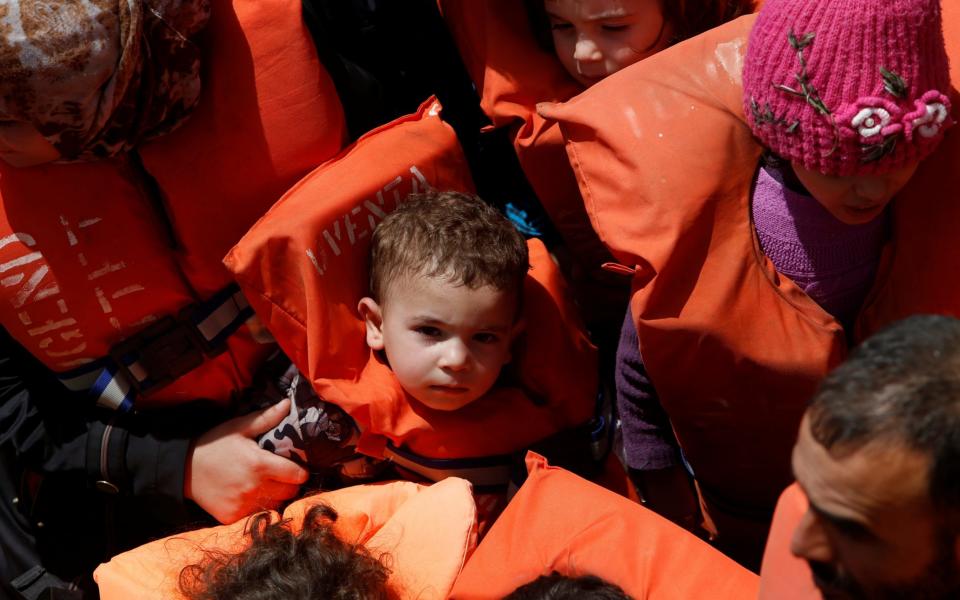 Child migrants wait to be brought onto the Malta-based NGO Migrant Offshore Aid Station ship Phoenix during a rescue operation in the central Mediterranean off the Libyan coastal town of Sabratha - Credit: Reuters