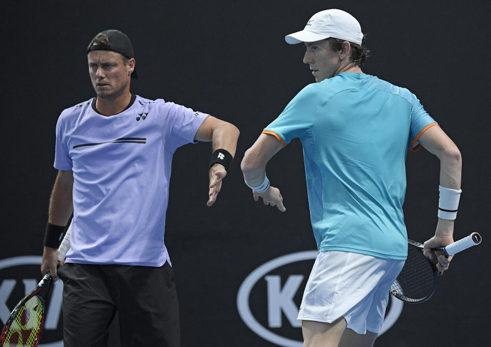 Australia's Lleyton Hewitt celebrates with compatriot John-Patrick Smith, left, during their first round doubles match against New Zealand's Marcus Daniels and Wesly Koolhof of the Netherlands at the Australian Open tennis championships in Melbourne, Australia, Thursday, Jan. 17, 2019. (AP Photo/Andy Brownbill)