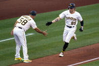 Pittsburgh Pirates' Jack Suwinski (65) is greeted by third base coach Mike Rabelo after hitting a solo home run off Milwaukee Brewers starting pitcher Adrian Houser during the second inning of a baseball game in Pittsburgh, Thursday, June 30, 2022. (AP Photo/Gene J. Puskar)