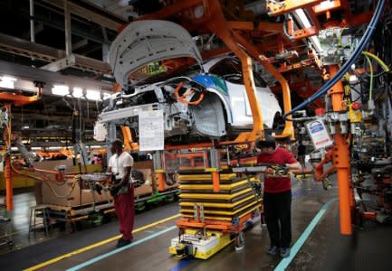 General Motors assembly workers connect a battery pack underneath a partially assembled 2018 Chevrolet Bolt EV vehicle on the assembly line at  Orion Assembly in Lake Orion, Michigan, U.S., March 19, 2018.  Photo taken March 19, 2018.   REUTERS/Rebecca Cook