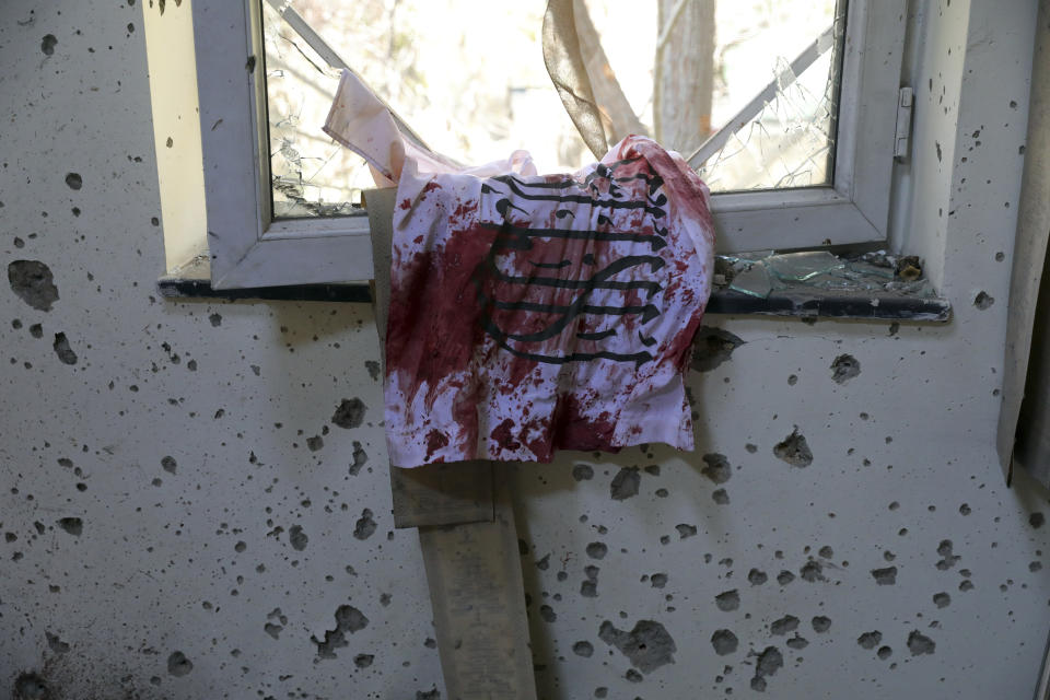 A blood-stained Taliban flag is seen on the window inside the Kabul University after a deadly attack in Kabul, Afghanistan, Tuesday, Nov. 3, 2020. The brazen attack by gunmen who stormed the university has left many dead and wounded in the Afghan capital. The assault sparked an hours-long gun battle. (AP Photo/Rahmat Gul)