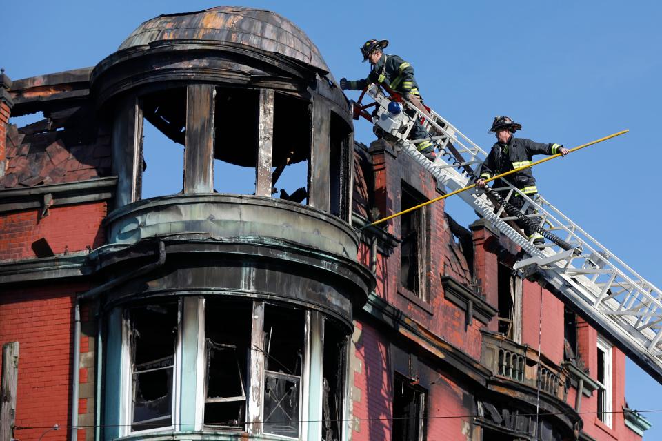 In this file photo from the March fire at the Royal Crown rooming house, New Bedford firefighters search for a missing resident. CISM team member and city firefighter Lance Brightman says firefighters' taking care of their mental health is an important part of the job, especially after an incident such as this one.