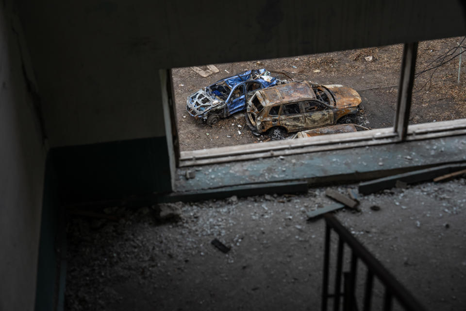 Destroyed cars seen on the street from a window on an apartment block that was hit by a Russian missile.