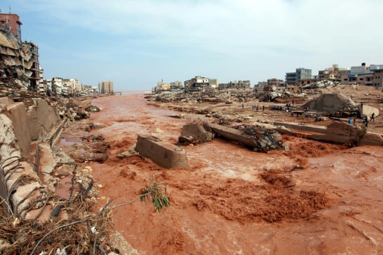 Des personnes observent les dégâts causés par les inondations à Derna, dans l'est de la Libye, le 11 septembre 2023 (-)