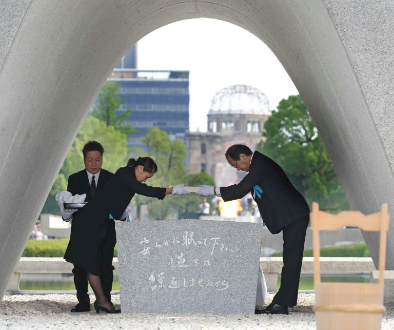 Hiroshima Mayor Kazumi Matsui (R) offers new list of the A-bomb dead, updated since last year's anniversary, during the 71st memorial service, at the Peace Memorial Park, on August 6, 2016
