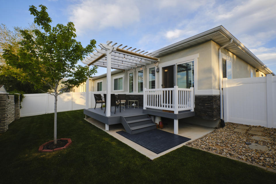 new deck with pergola off the back of a small suburban house