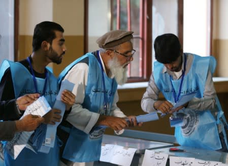 Afghan election commission workers count ballot papers of the presidential election in Kabul