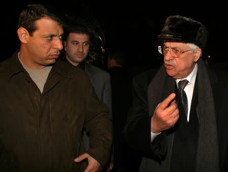 Palestinian President Mahmoud Abbas (R) and his then aide Mohammad Dahlan, walk out Abbas' house in Gaza in this February 11, 2005 file photo. REUTERS/Mohammed Salem/Files