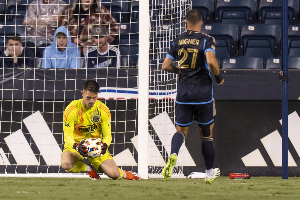 Philadelphia Union's Oliver Semmle, left, makes the save as Kai Wagner, right, watches during the second half of the team's MLS soccer match against Atlanta United on Wednesday, May 29, 2024, in Chester, Pa. (AP Photo/Chris Szagola)