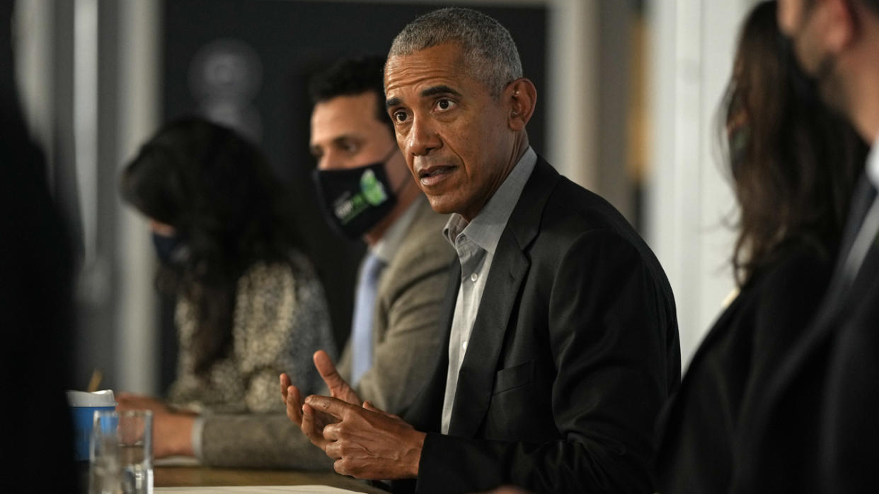 Former President Barack Obama sits at a table, flanked by other participants, during a meeting at the United Nations climate summit in Glasgow, Scotland. 