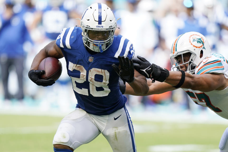 Indianapolis Colts running back Jonathan Taylor (28) avoids a tackle by Miami Dolphins outside linebacker Brennan Scarlett (57), during the second half of an NFL football game, Sunday, Oct. 3, 2021, in Miami Gardens, Fla. (AP Photo/WIlfredo Lee)