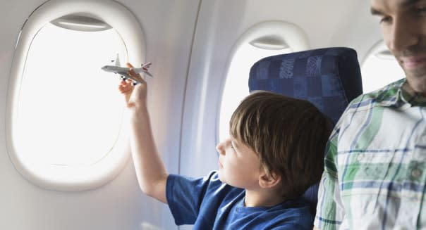 Boy playing with toy plane in airplane