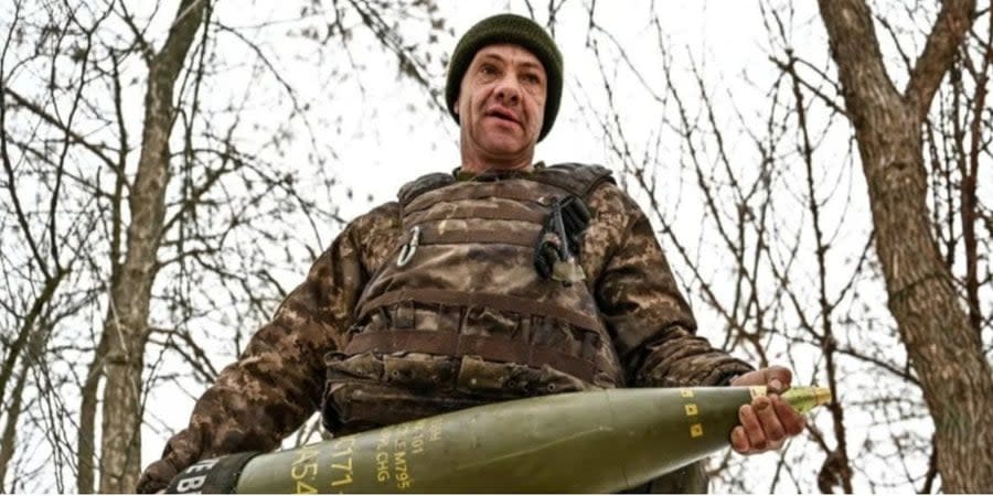 A Ukrainian soldier carries a 155-mm artillery shell to a position in Zaporizhzhia region