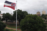 A Mississippi state flag flies outside the Capitol in Jackson, Miss., Thursday, June 25, 2020. Athletic coaches and their staffs from the state's public universities held a joint news conference and called for a change in the Mississippi state flag. Additionally, several head coaches met with both the lieutenant governor and Speaker Philip Gunn, as well as their lawmakers, to lobby for the change. The current flag has in the canton portion of the banner the design of the Civil War-era Confederate battle flag, that has been the center of a long-simmering debate about its removal or replacement. (AP Photo/Rogelio V. Solis)