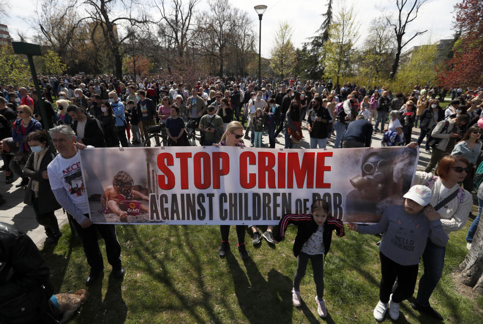 People hold a banner during a protest in front of the Serbian Parliament building in Belgrade, Serbia, Saturday, April 10, 2021. Environmental activists are protesting against worsening environmental situation in Serbia. (AP Photo/Darko Vojinovic)