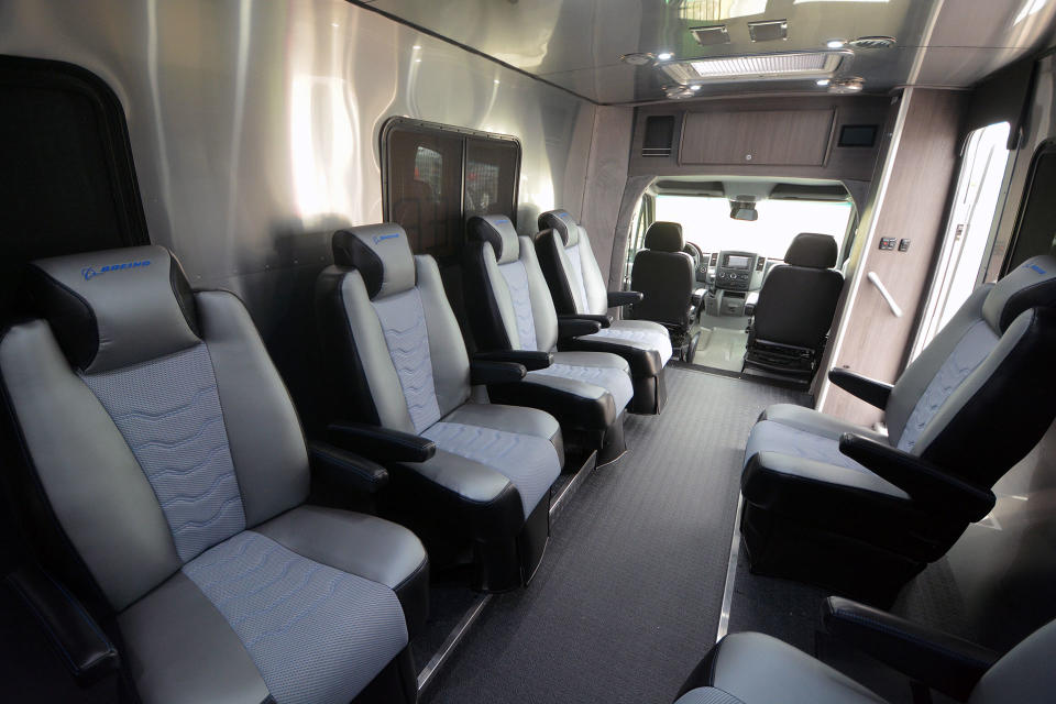 the gray interior of a large van, showing six bucket seats