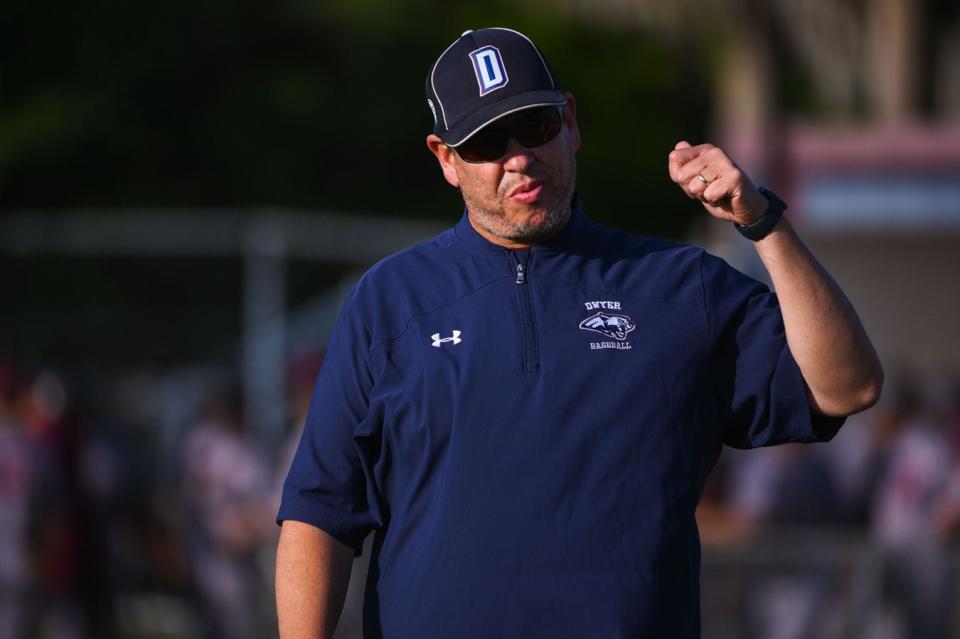 Dwyer head coach Alex Morales signals to the team to take the field to start the game between Trinity Christian and host Dwyer in Palm Beach Gardens on April 19, 2022. Final score, Trinity Christian, 3, Dwyer, 2.