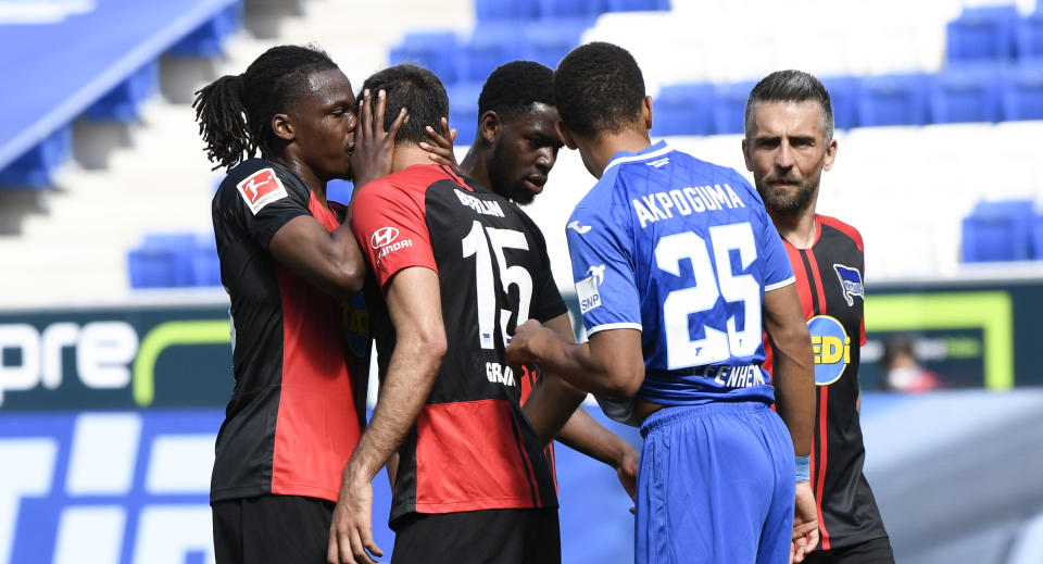 Hertha's Dedryck Boyata either kissed or whispered to teammate Marko Grujic after a goal was scored on Saturday, violating the Bundesliga's social distancing guidelines for celebrations. (Photo by Thomas Kienzle/Pool via Getty Images)