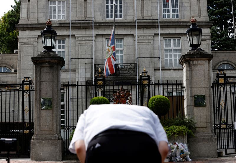 A man bows his head to mourn the death of Queen Elizabeth outside the British Embassy in Tokyo