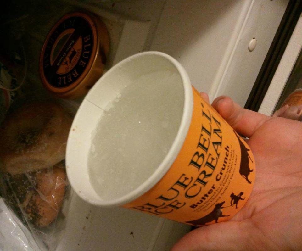 Hand holding an ice cream container  with just ice and water