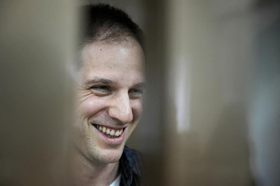 FILE - Wall Street Journal reporter Evan Gershkovich smiles as he stands in a defendants’ cage in a courtroom at the Moscow City Court, in Moscow, Russia, on Tuesday, Oct. 10, 2023. Gershkovich, a U.S. citizen, has been jailed for a year after being accused by Russia of espionage – which he, his employer and the U.S. government deny. (AP Photo/Alexander Zemlianichenko, File)