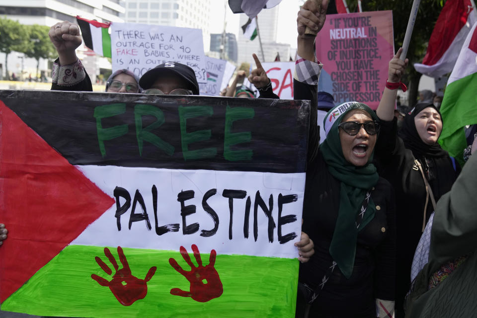 Protesters shout slogans during a rally supporting the Palestinian people outside the building housing the U.N. representative office in Jakarta, Indonesia, Friday, Oct. 20, 2023. Hundreds of people staged protests in Indonesia's capital Friday to denounce the staunch American support for Israel and demand an end to Israeli airstrikes on the Gaza Strip. (AP Photo/Dita Alangkara)