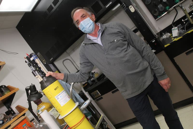 Johnson stands next to a robotic ocean float in a laboratory at the Monterey Bay Aquarium Research Institute in Moss Landing