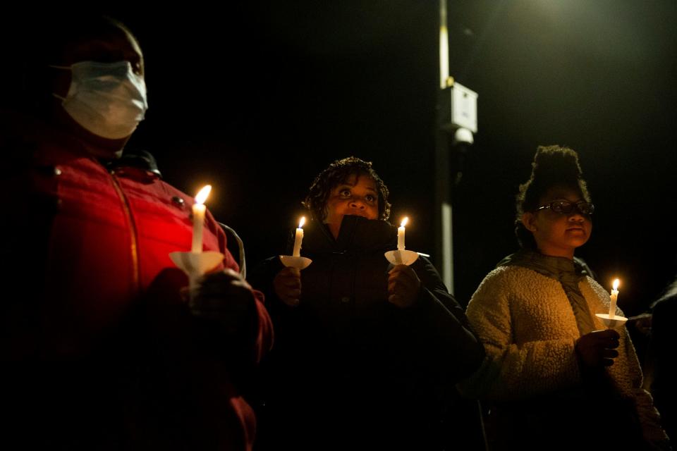 Attendees hold candles during a candlelight vigil for Tyre Nichols held at the site where he was beaten to death by Memphis Police Department officers on the one year anniversary of his death in Memphis, Tenn., on Sunday, January 7, 2024. Behind the attendees, the MPD camera that recorded part of the traffic stop and beating can be seen.